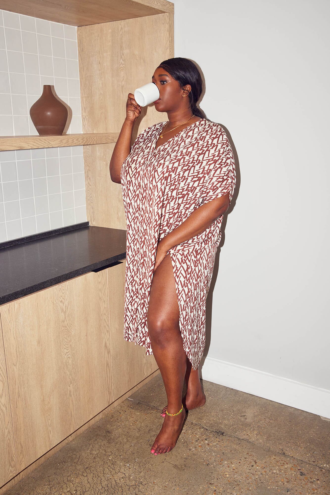 Model sipping coffee in the Mikal Button Down Maternity Kaftan by M Street